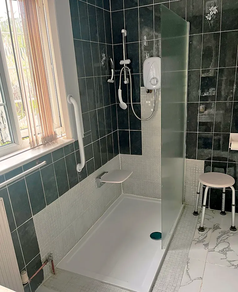 Walk-in shower with grab rails, seat and level-access tray, fitted by Howells Plumbing in Poole